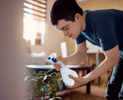 man-with-down-syndrome-watering-houseplants-with-s-2022